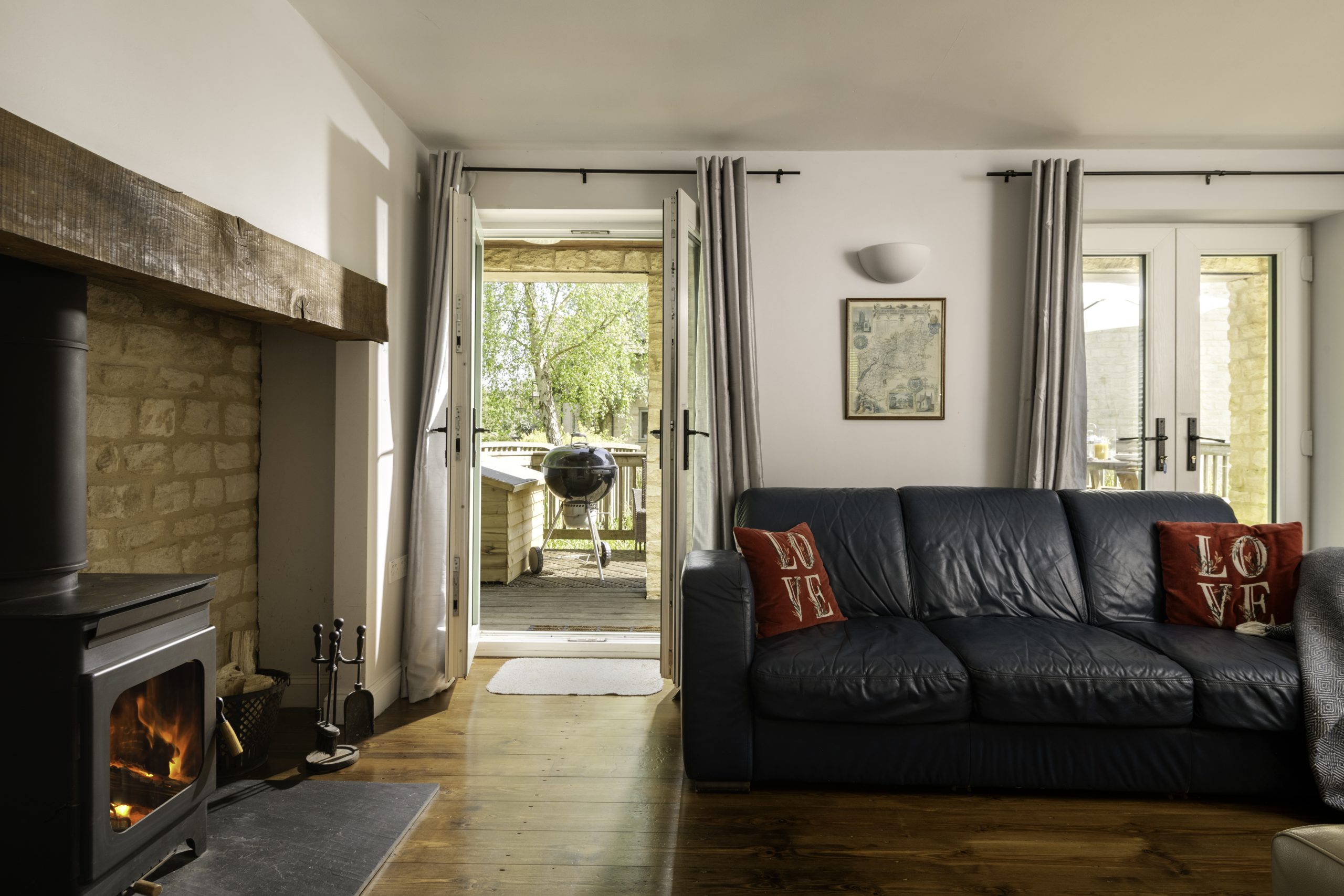 Cotswold Spa holiday Lower Mill estate cottage living room sofa log fire sundeck