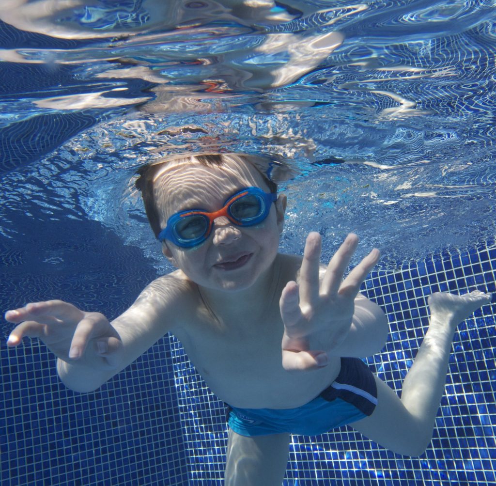 Child Swimming At Lower Mill Estate Pool vert